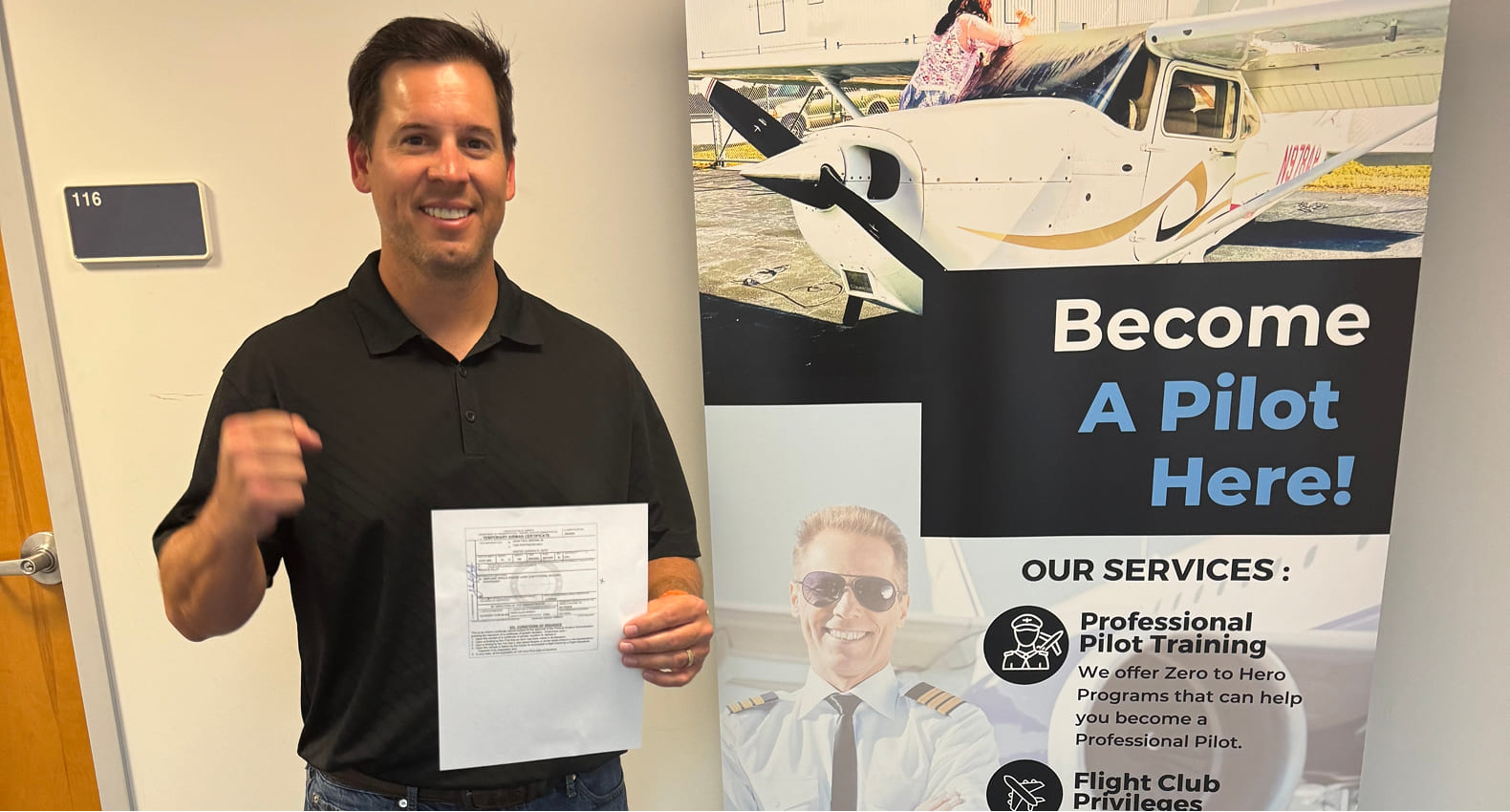 Young pilot standing next to an airplane.