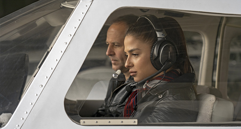 Young woman about to fly a plane with an instructor next to her.