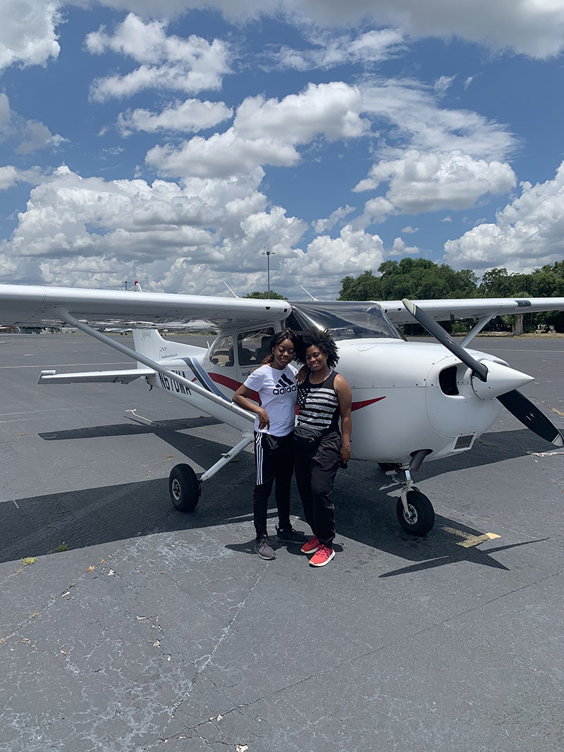 Women standing in front an Aero Global Aviation Academy's plane